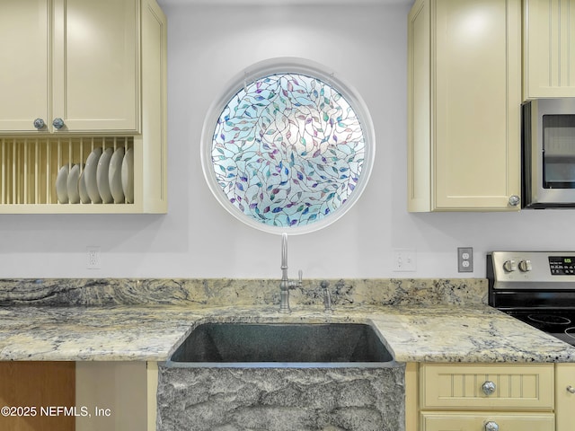 70 Weeden St + Guest House, Unit Guest House, Saint Augustine, FL 32084 - kitchen with cream cabinetry, stainless steel appliances, light stone counters, and a sink