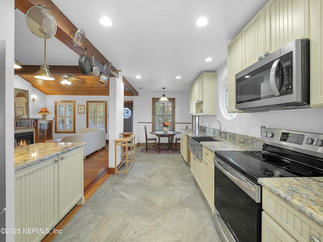 70 Weeden St + Guest House, Unit Guest House, Saint Augustine, FL 32084 - kitchen with pendant lighting, a sink, cream cabinetry, a lit fireplace, and stainless steel appliances