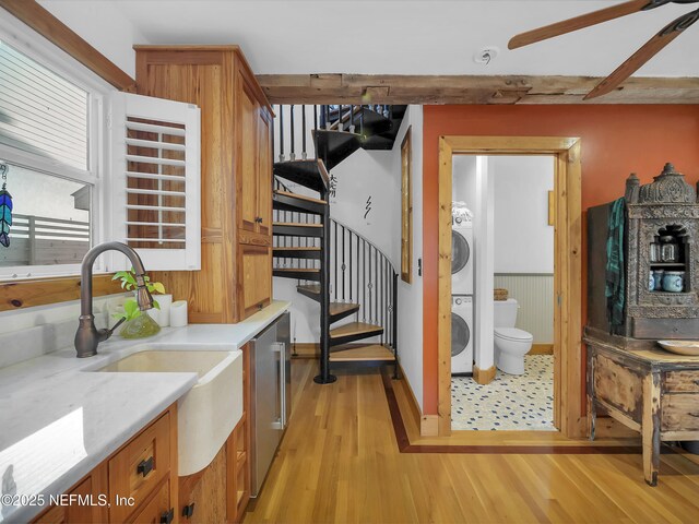 70 Weeden St + Guest House, Unit Guest House, Saint Augustine, FL 32084 - interior space with brown cabinetry, light wood finished floors, a sink, light countertops, and stacked washer / drying machine