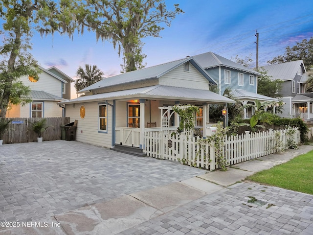 70 Weeden St + Guest House, Unit Guest House, Saint Augustine, FL 32084 - country-style home featuring covered porch, a fenced front yard, a gate, and metal roof