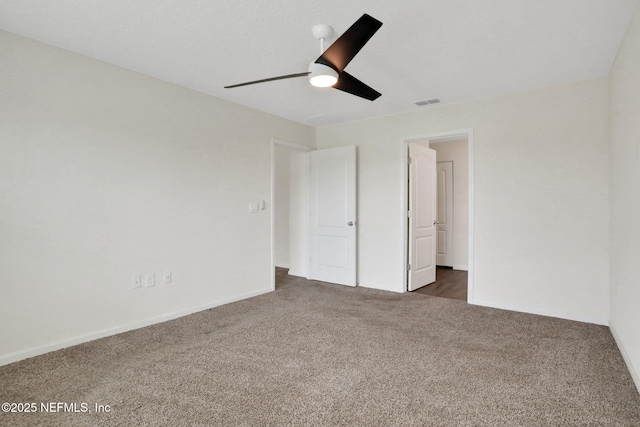 unfurnished bedroom featuring carpet flooring, baseboards, a ceiling fan, and visible vents