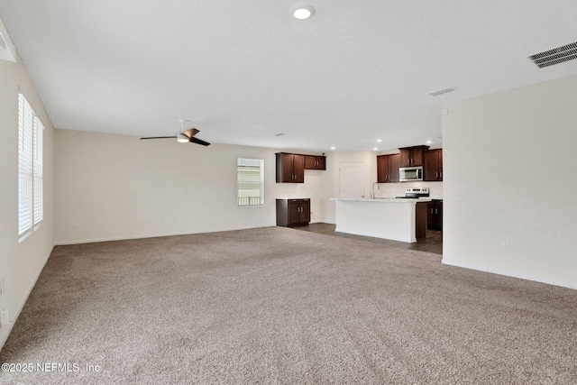 unfurnished living room with visible vents, a ceiling fan, dark carpet, and recessed lighting