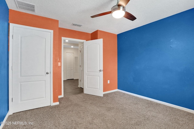 unfurnished bedroom featuring ceiling fan, carpet floors, baseboards, and visible vents