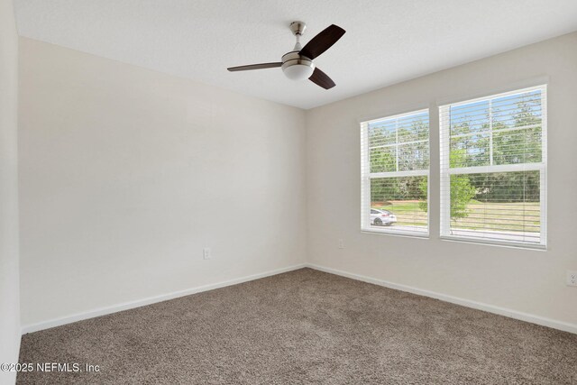 carpeted empty room with baseboards and ceiling fan