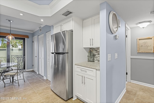 890 A1A Beach Blvd Unit 39, Saint Augustine, FL 32080 - kitchen featuring freestanding refrigerator, crown molding, white cabinets, decorative backsplash, and light tile patterned flooring