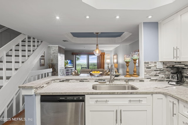 890 A1A Beach Blvd Unit 39, Saint Augustine, FL 32080 - kitchen featuring stainless steel dishwasher, a tray ceiling, backsplash, white cabinets, and light stone counters