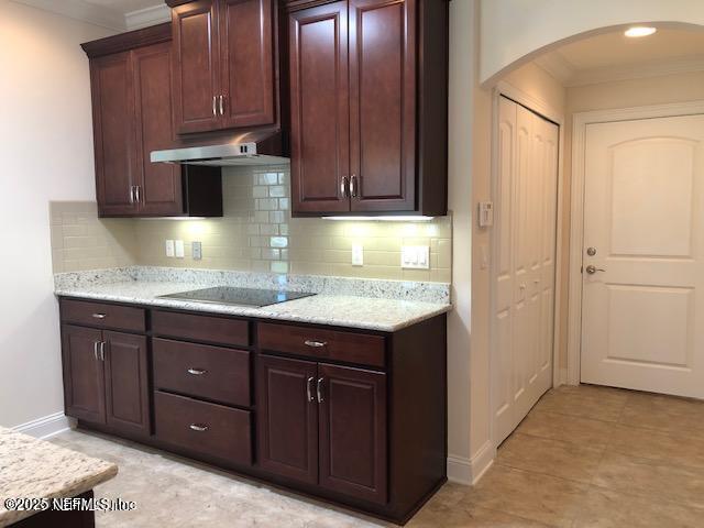 71 Utina Way, Saint Augustine, FL 32084 - kitchen featuring under cabinet range hood, ornamental molding, black electric stovetop, and arched walkways
