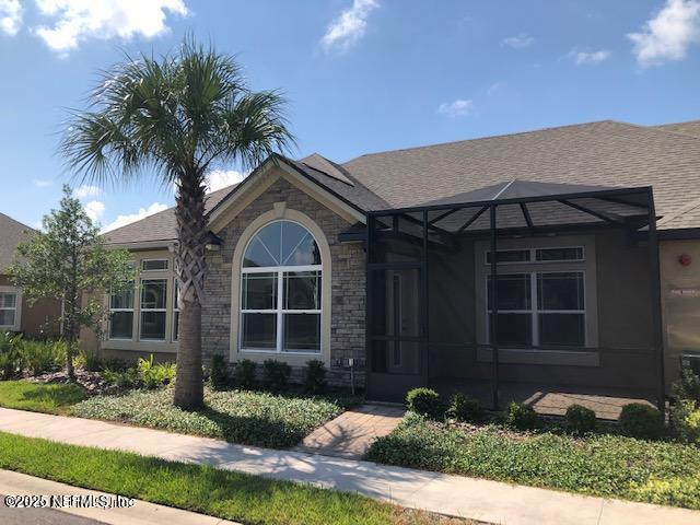 71 Utina Way, Saint Augustine, FL 32084 - ranch-style home featuring stone siding, roof with shingles, and glass enclosure