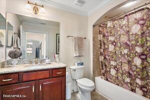 71 Utina Way, Saint Augustine, FL 32084 - bathroom with toilet, ornamental molding, vanity, and shower / bathtub combination with curtain