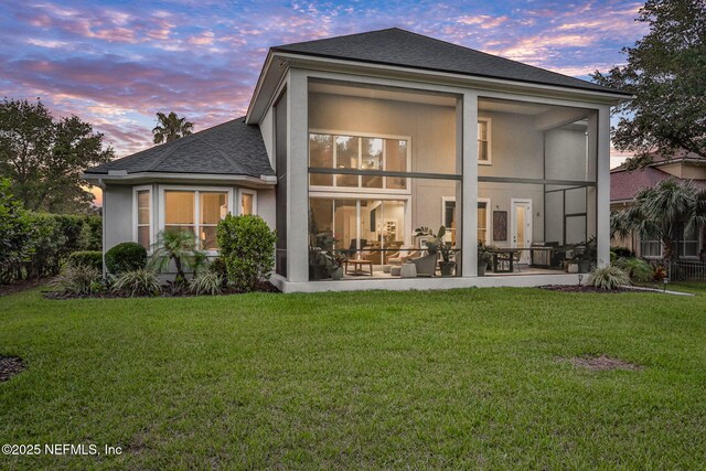 105 Calle Norte, Saint Augustine, FL 32095 - rear view of house with roof with shingles, a lawn, stucco siding, and a sunroom