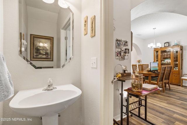 bathroom featuring a sink, an inviting chandelier, and wood finished floors