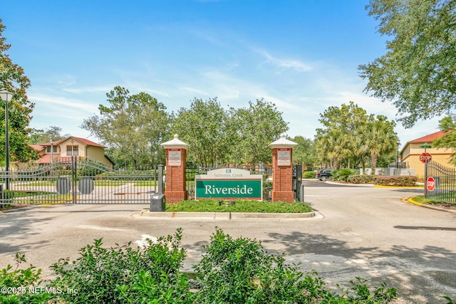 community sign featuring a gate and fence
