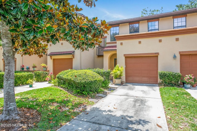 multi unit property with concrete driveway, stucco siding, and a garage