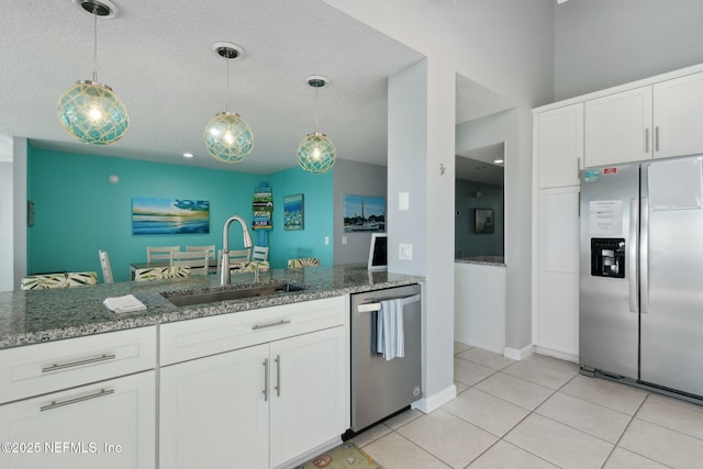 2122 S Fletcher Ave, Fernandina Beach, FL 32034 - kitchen featuring light stone countertops, hanging light fixtures, a sink, white cabinetry, and appliances with stainless steel finishes