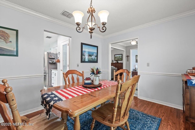 2632 Loopridge Dr, Orange Park, FL 32065 - dining room with a chandelier, wood finished floors, crown molding, and baseboards