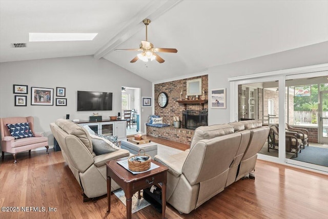 2632 Loopridge Dr, Orange Park, FL 32065 - living room with wood finished floors, ceiling fan, a brick fireplace, and a skylight