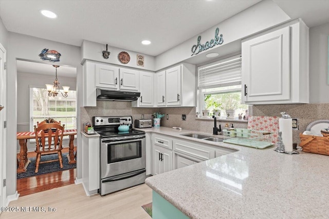 2632 Loopridge Dr, Orange Park, FL 32065 - kitchen featuring stainless steel range with electric stovetop, under cabinet range hood, a sink, a chandelier, and light countertops
