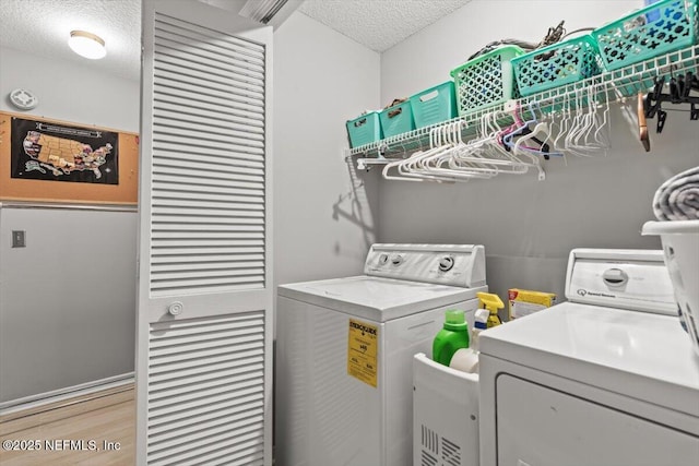 2632 Loopridge Dr, Orange Park, FL 32065 - laundry area with a textured ceiling, washing machine and dryer, and light wood-style floors