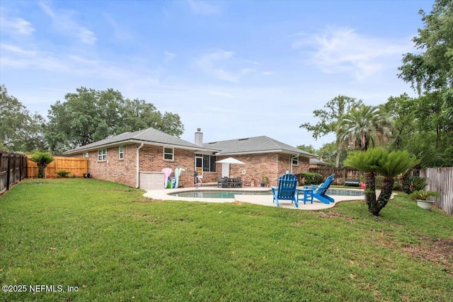 2632 Loopridge Dr, Orange Park, FL 32065 - rear view of property featuring brick siding, a patio area, an attached garage, and a chimney
