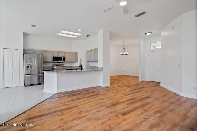 1856 Weston Cir, Fleming Island, FL 32003 - kitchen with light wood-style flooring, gray cabinetry, visible vents, ceiling fan with notable chandelier, and stainless steel appliances