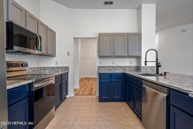 kitchen with a sink, blue cabinets, visible vents, and appliances with stainless steel finishes