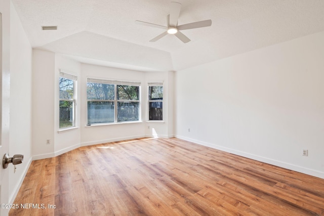 unfurnished room with ceiling fan, light wood-style flooring, baseboards, and visible vents