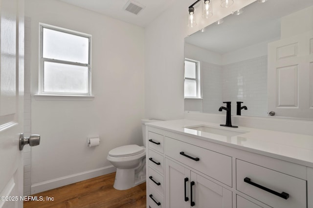 bathroom with vanity, toilet, plenty of natural light, and visible vents