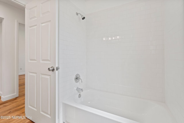 full bathroom with baseboards, wood finished floors, and shower / bath combination