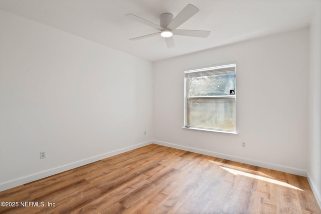 spare room with ceiling fan, light wood-style flooring, and baseboards