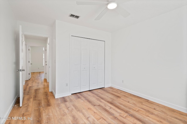 unfurnished bedroom with a closet, light wood-type flooring, visible vents, and baseboards