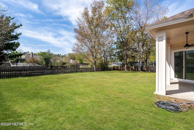 view of yard with a fenced backyard and ceiling fan