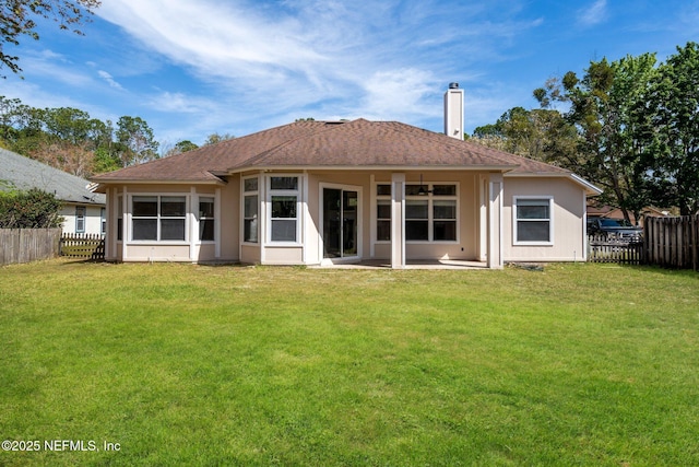 rear view of property with a fenced backyard, a patio, a chimney, and a lawn