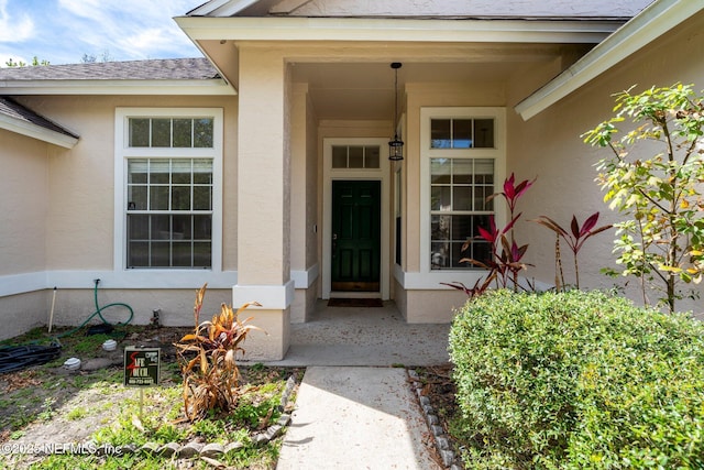 doorway to property featuring stucco siding