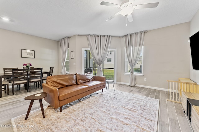 10350 Alder Creek Ln, Jacksonville, FL 32222 - living area with wood tiled floors, a ceiling fan, baseboards, and a textured ceiling