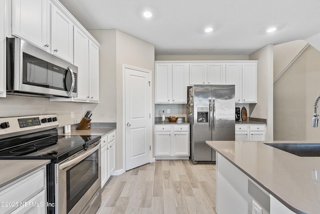 10350 Alder Creek Ln, Jacksonville, FL 32222 - kitchen featuring stainless steel appliances, a sink, light wood-style floors, white cabinets, and recessed lighting