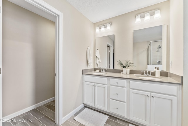 10350 Alder Creek Ln, Jacksonville, FL 32222 - full bathroom with a stall shower, double vanity, wood finish floors, baseboards, and a textured ceiling