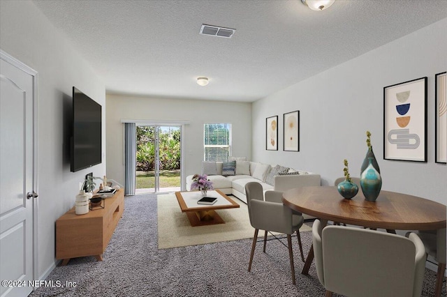 carpeted living room featuring visible vents and a textured ceiling
