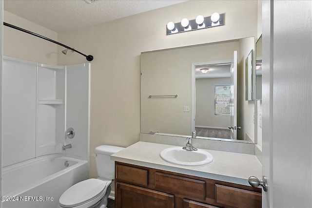 bathroom featuring shower / bath combination, vanity, toilet, and a textured ceiling