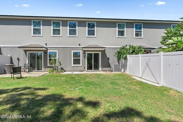 rear view of property with a yard, stucco siding, a patio area, and a fenced backyard