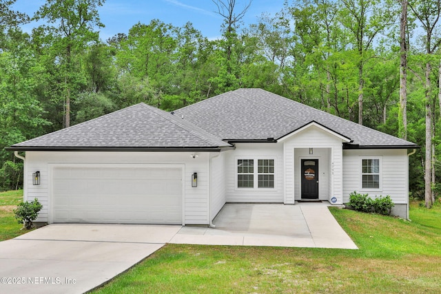 ranch-style home featuring roof with shingles, concrete driveway, an attached garage, and a front yard