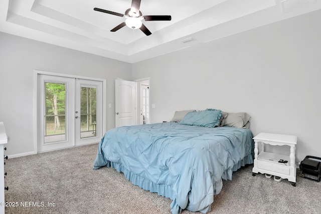 bedroom featuring a tray ceiling, carpet, access to outside, and visible vents