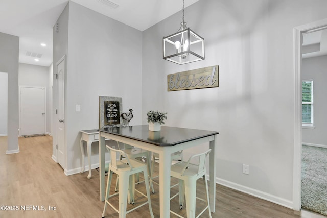 dining space featuring a notable chandelier, recessed lighting, baseboards, visible vents, and light wood-style floors