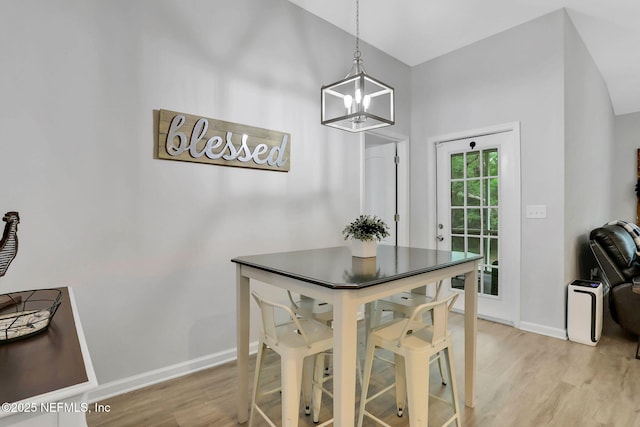 dining room featuring a chandelier, light wood-style flooring, and baseboards