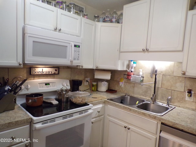 kitchen featuring white appliances, a sink, white cabinetry, backsplash, and light countertops