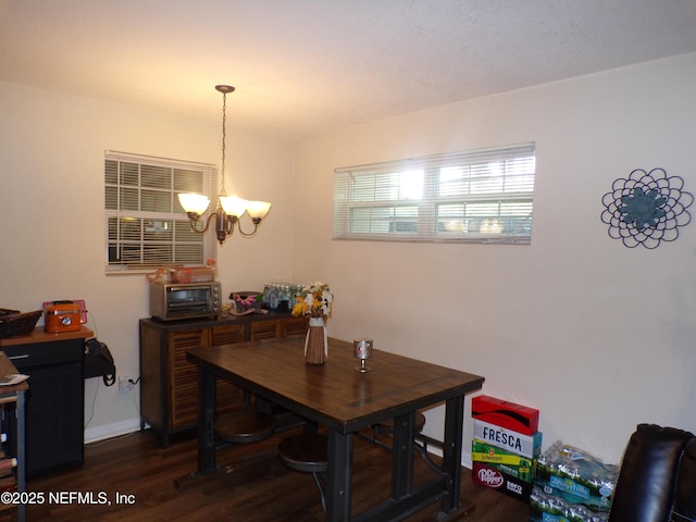 dining area with a notable chandelier, dark wood-type flooring, and a toaster