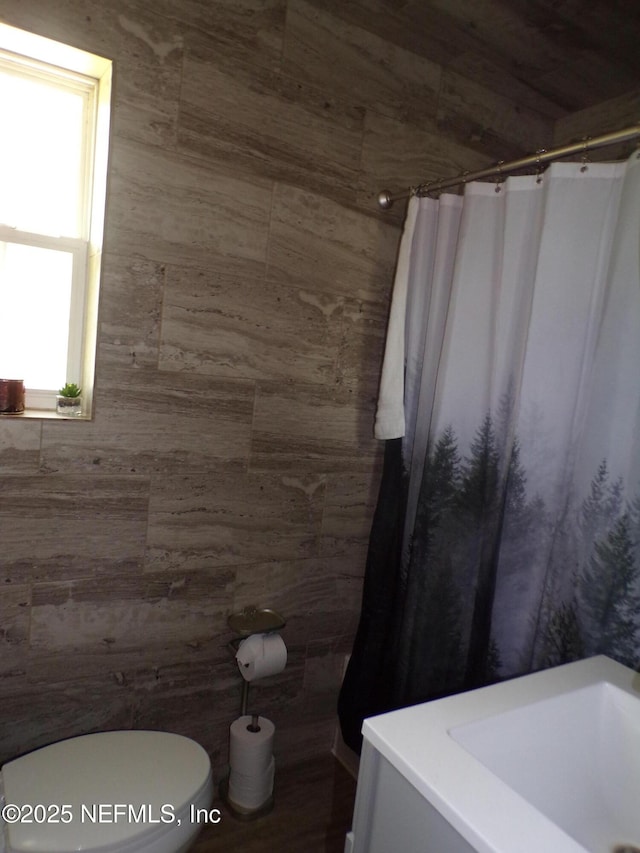 full bathroom with toilet and a shower with curtain