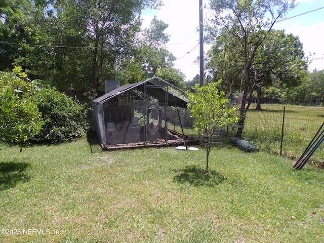 view of yard featuring an outdoor structure, exterior structure, and fence