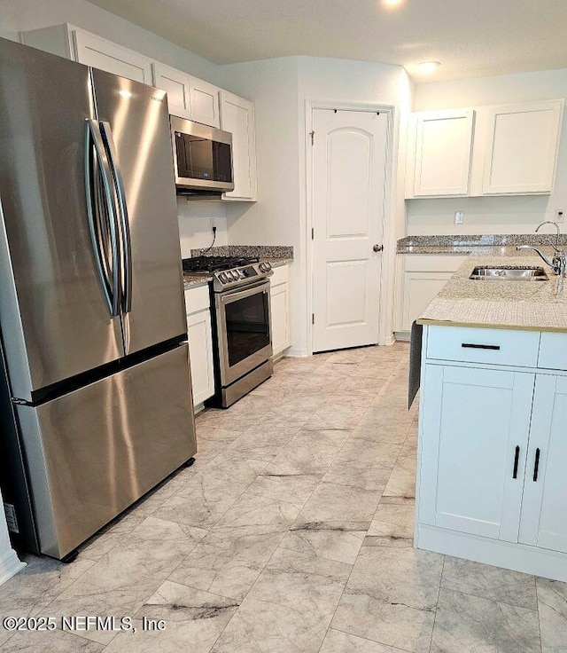 497 Live Oak Loop, Crescent City, FL 32112 - kitchen featuring a sink, white cabinetry, light stone countertops, appliances with stainless steel finishes, and marble finish floor