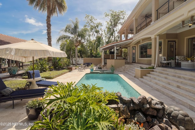 view of swimming pool featuring a patio area, a fenced in pool, ceiling fan, and fence