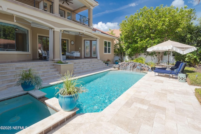 view of swimming pool with a patio, a pool with connected hot tub, french doors, and ceiling fan